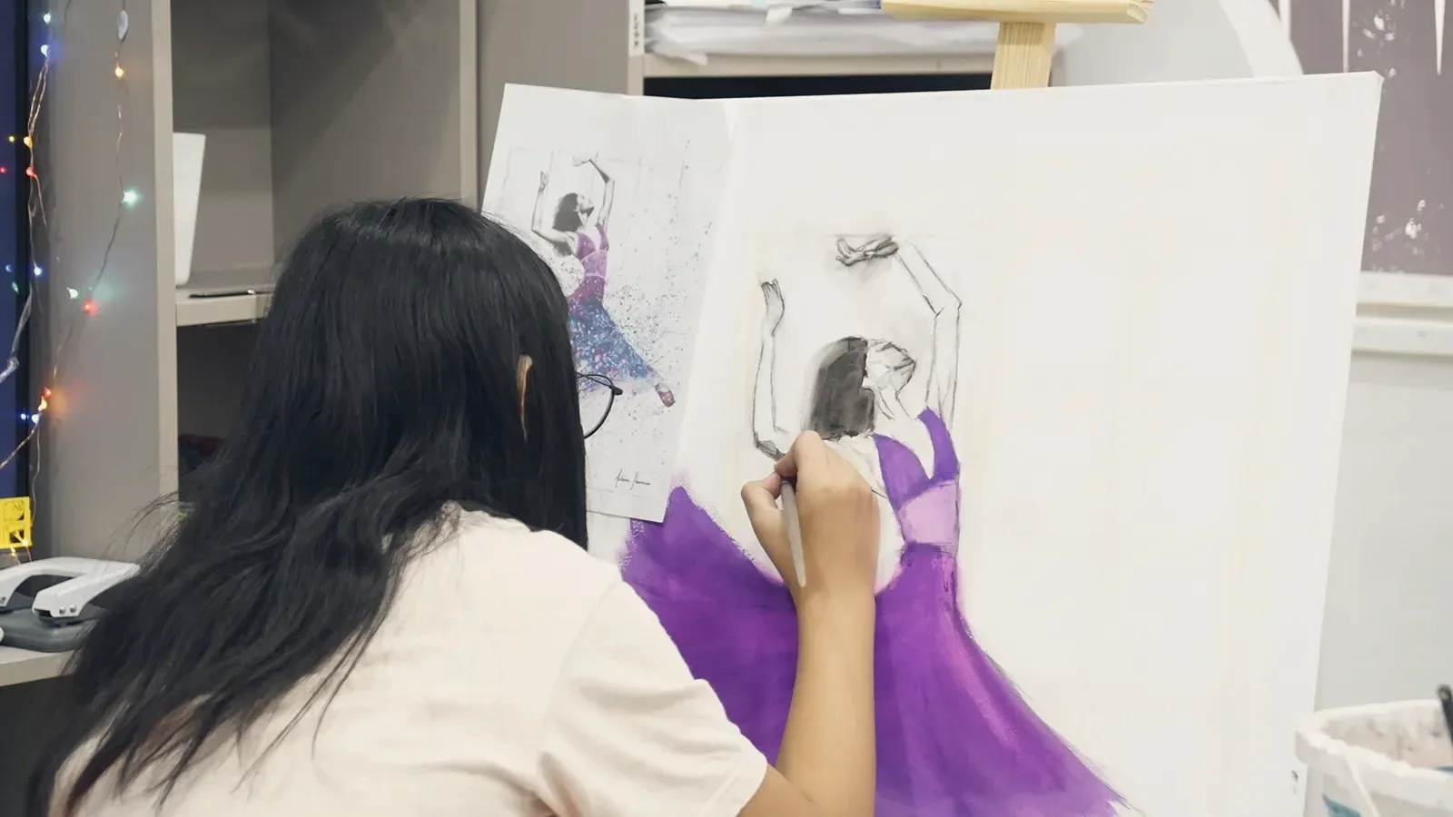 A teenage OpenKids student painting a ballet dancer at her easel