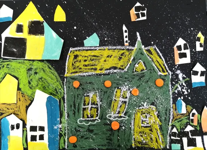 A snowy night town on black paper with a large oil pastel house and cut-paper cottages