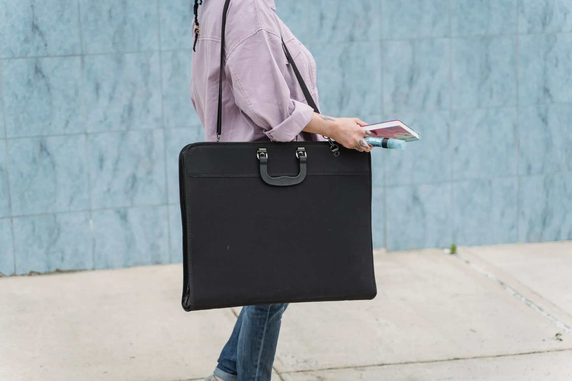 A young artist carrying her portfolio case to a review