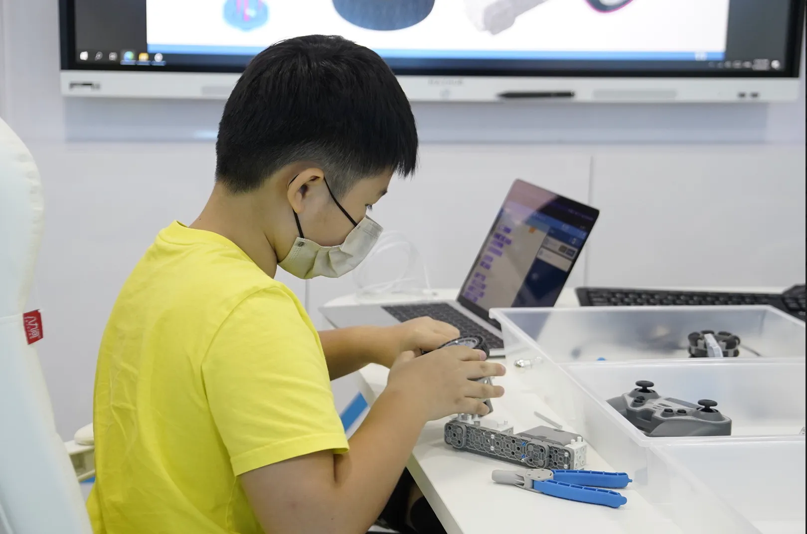 An OpenKids student building and programming his robot
