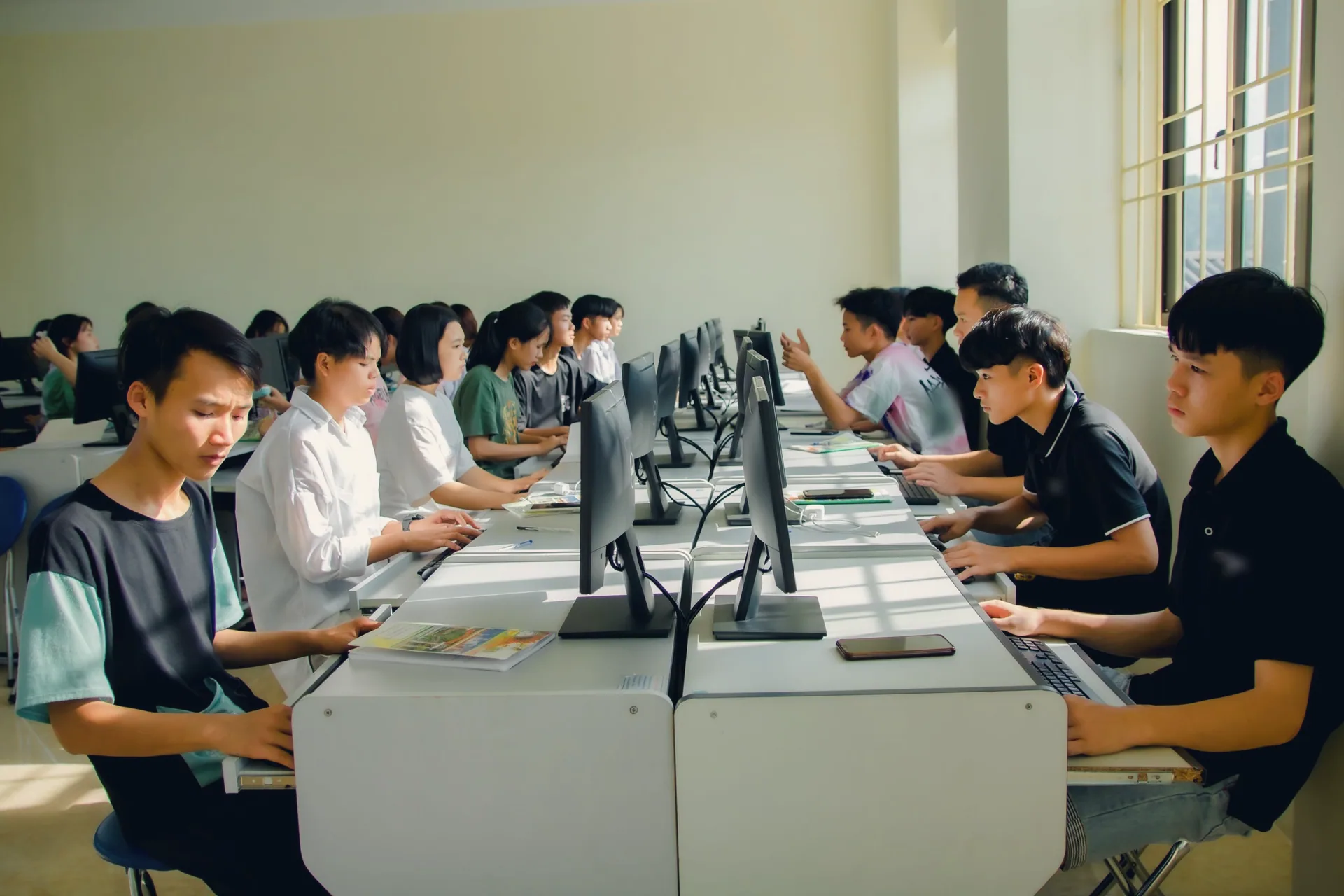 阳光洒进学校的电脑教室,一排排中学生在电脑前操作