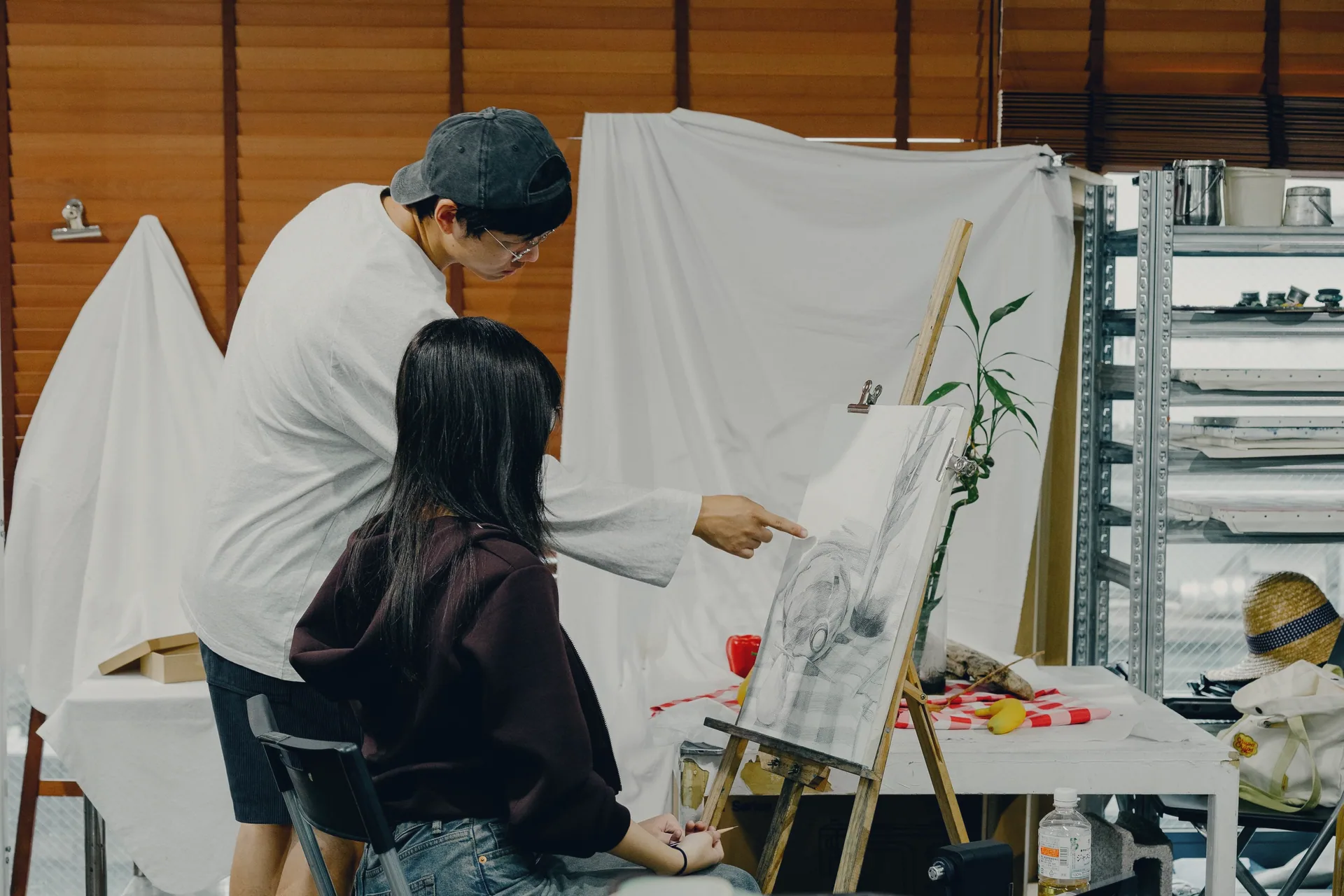 Two art students working at an easel in a studio