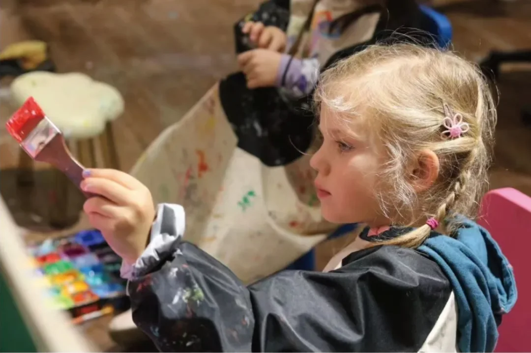 A child exploring colour with a paintbrush · Source article image